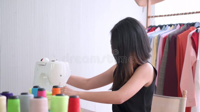 Giovane stilista cucisce una nuova collezione in studio di abbigliamento