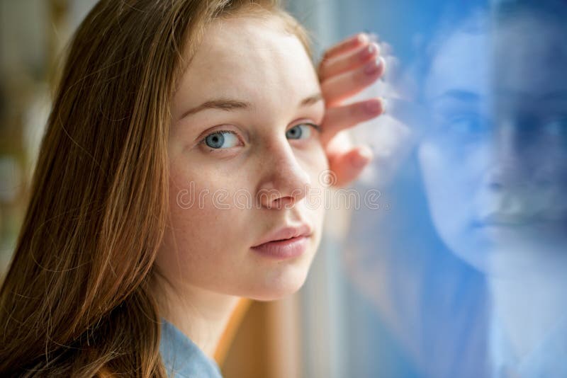 Giovane studente di college femminile solo depresso che fa una pausa una finestra alla sua scuola, esaminante la macchina fotogra fotografia stock libera da diritti