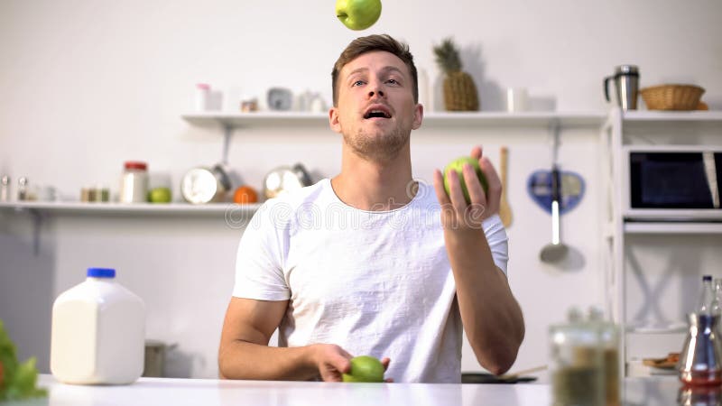 Giovane tipo che manipola le mele verdi, iniziando dieta e stile di vita sano, vitamine fotografia stock Giovane tipo che manipola le mele verdi, iniziando dieta e stile di vita sano, vitamine fotografia stock