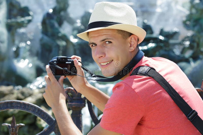 Giovane turista maschio che prende fotografia con la macchina fotografica digitale immagine stock Giovane turista maschio che prende fotografia con la macchina fotografica digitale immagine stock