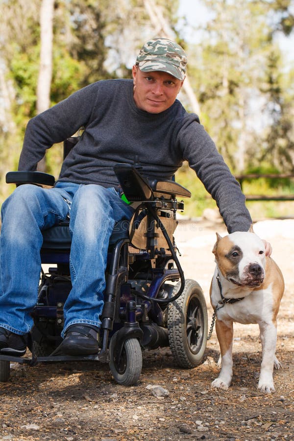 Giovane in una sedia a rotelle con il suo cane fedele.