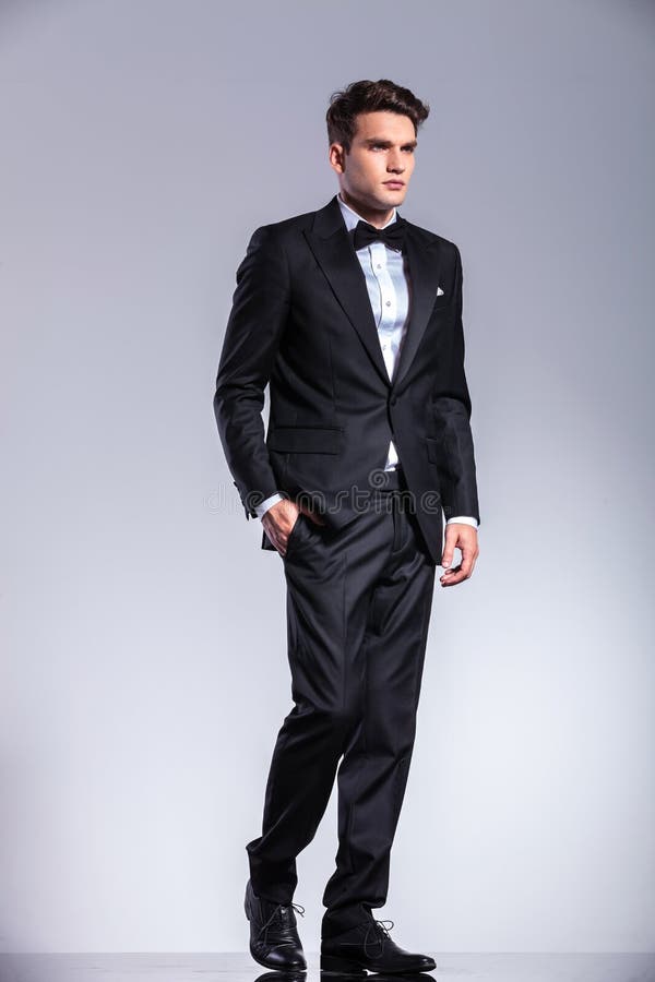 Giovane uomo alto di affari che cammina sul fondo dello studio fotografie stock libere da diritti Giovane uomo alto di affari che cammina sul fondo dello studio fotografie stock libere da diritti