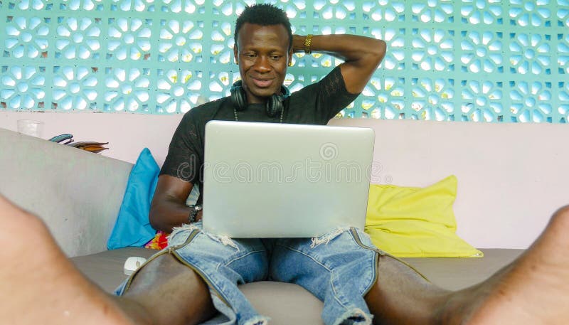 Giovane uomo americano di affari dell'africano nero bello e felice dei pantaloni a vita bassa che lavora con sorridere delle cuff fotografie stock Giovane uomo americano di affari dell'africano nero bello e felice dei pantaloni a vita bassa che lavora con sorridere delle cuff fotografie stock