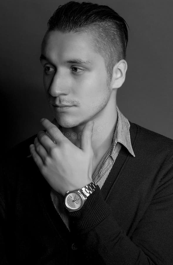 Giovane uomo bello elegante Uomo alla moda con il maglione d'uso di taglio di capelli alla moda con la camicia che posa sopra il fotografie stock libere da diritti Giovane uomo bello elegante Uomo alla moda con il maglione d'uso di taglio di capelli alla moda con la camicia che posa sopra il fotografie stock libere da diritti