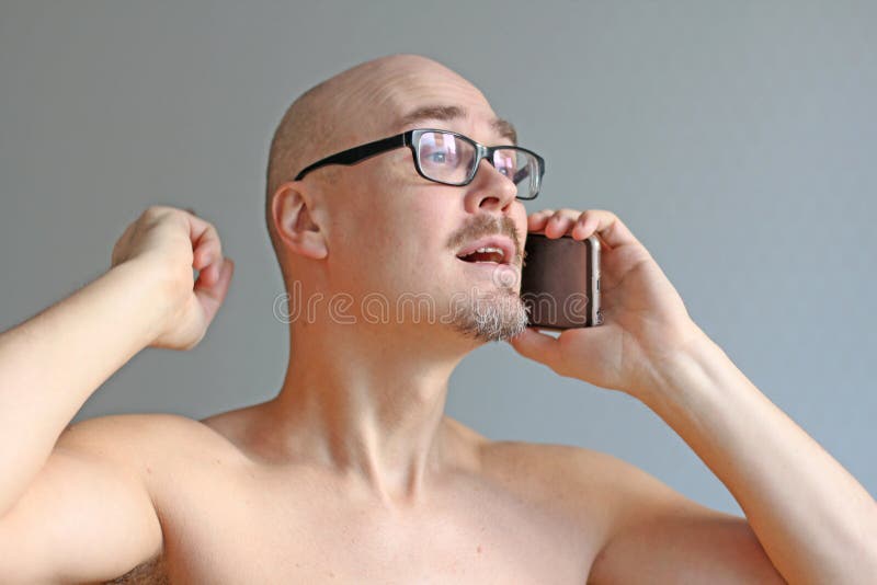 Giovane uomo calvo bello in vetri neri che parla sul telefono Ritratto del primo piano di un uomo Cattive notizie, tristezza, pro fotografie stock libere da diritti Giovane uomo calvo bello in vetri neri che parla sul telefono Ritratto del primo piano di un uomo Cattive notizie, tristezza, pro fotografie stock libere da diritti