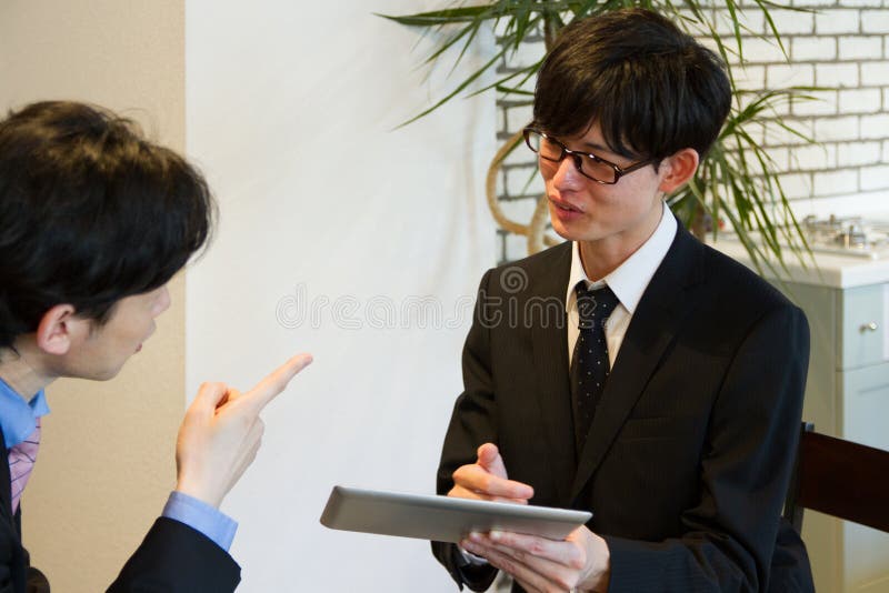 Giovane uomo d'affari che chiede al capo di controllare il suo piano con il dispositivo della compressa fotografia stock libera da diritti Giovane uomo d'affari che chiede al capo di controllare il suo piano con il dispositivo della compressa fotografia stock libera da diritti