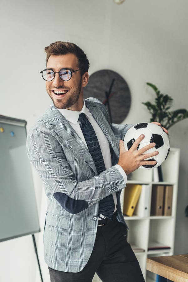 giovane uomo d'affari felice con pallone da calcio fotografie stock libere da diritti giovane uomo d'affari felice con pallone da calcio fotografie stock libere da diritti