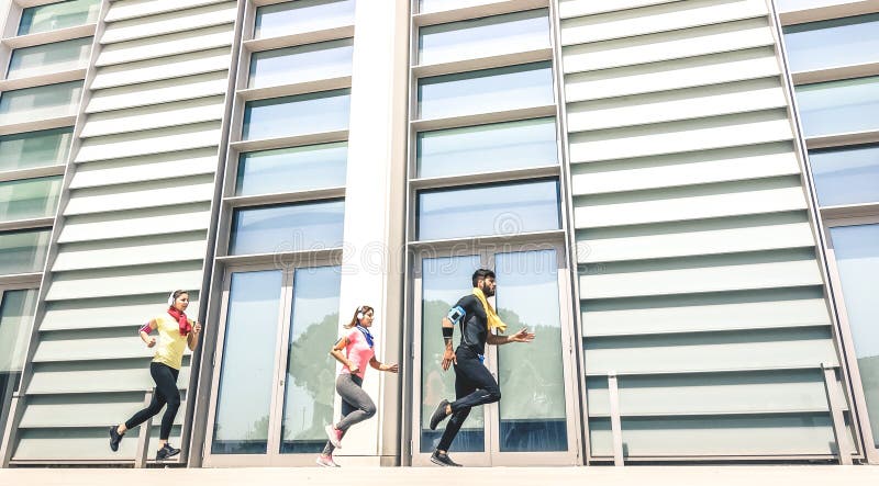 Giovani che corrono nell'area urbana moderna - ragazze di forma fisica che corrono con la vettura maschio dell'istruttore nella c fotografia stock libera da diritti Giovani che corrono nell'area urbana moderna - ragazze di forma fisica che corrono con la vettura maschio dell'istruttore nella c fotografia stock libera da diritti