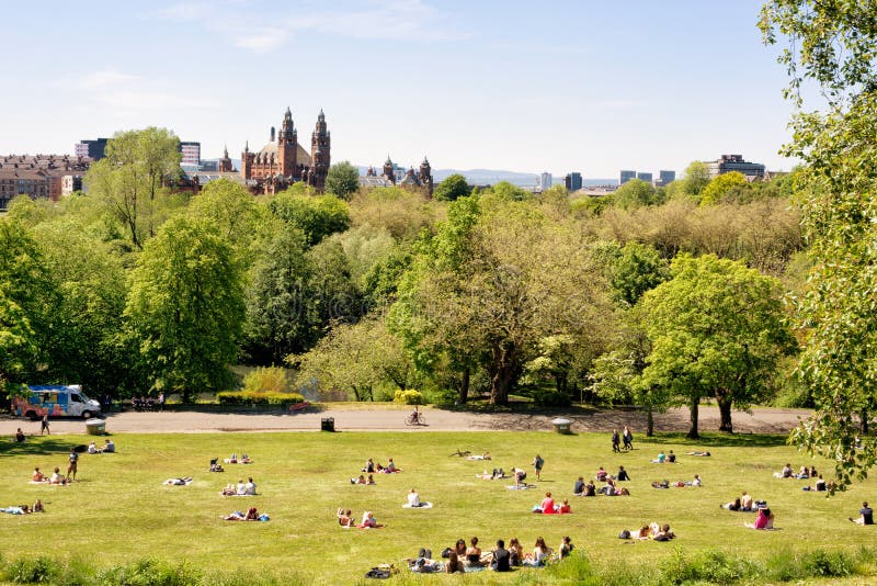 Giovani che godono di un giorno soleggiato caldo nel parco di Kelvingrove di Glasgow fotografia stock libera da diritti Giovani che godono di un giorno soleggiato caldo nel parco di Kelvingrove di Glasgow fotografia stock libera da diritti