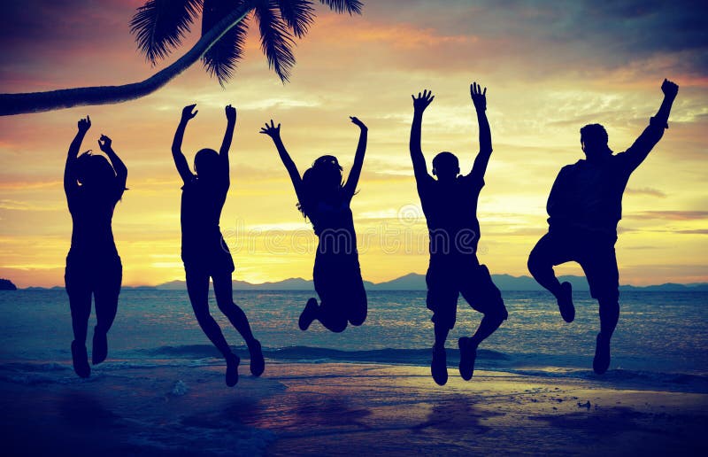 Giovani che saltano con l'eccitazione sulla spiaggia