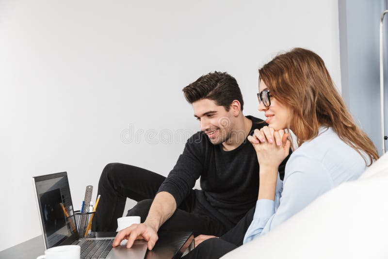 Giovani coppie allegre dei colleghi che lavorano insieme fotografie stock libere da diritti Giovani coppie allegre dei colleghi che lavorano insieme fotografie stock libere da diritti