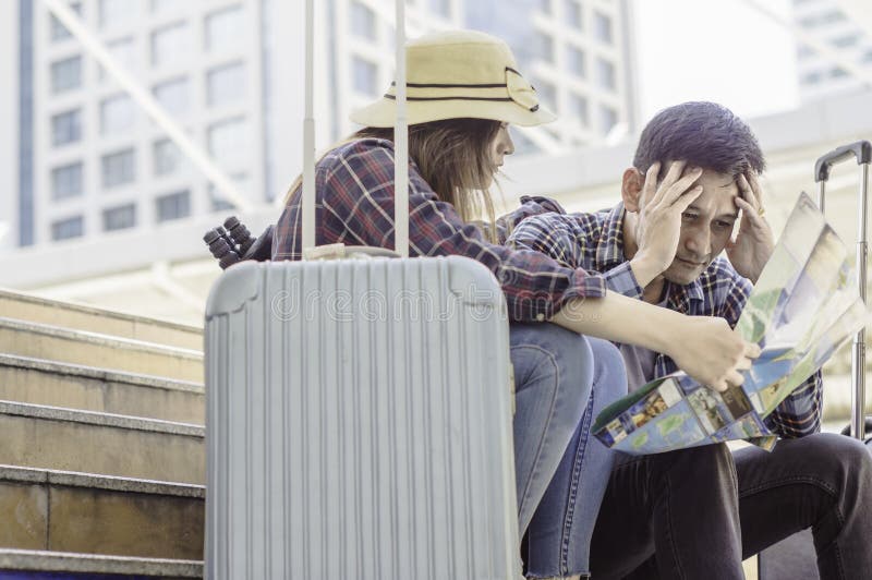 Giovani coppie asiatiche dei viaggiatori, sguardo alla mappa e sforzo perché fotografia stock libera da diritti Giovani coppie asiatiche dei viaggiatori, sguardo alla mappa e sforzo perché fotografia stock libera da diritti