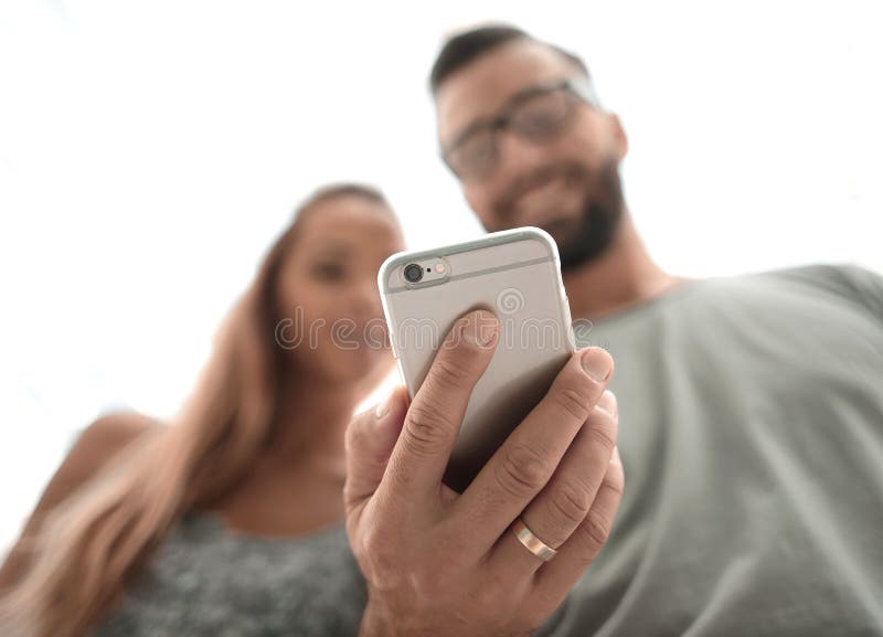 Giovani coppie che guardano le foto sullo smartphone immagine stock libera da diritti Giovani coppie che guardano le foto sullo smartphone immagine stock libera da diritti