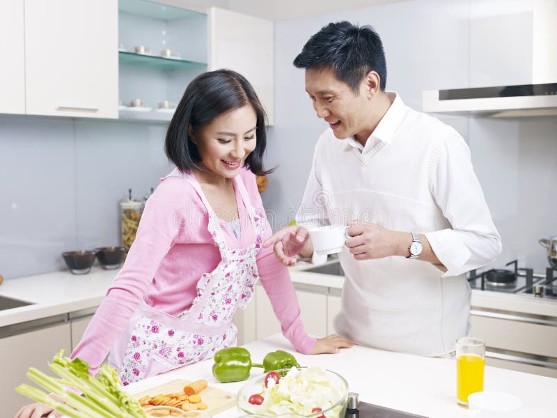 Young asian couple talking in kitchen. Young asian couple talking in kitchen.