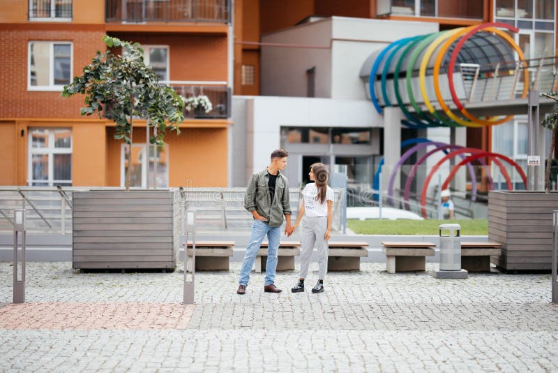 Giovani coppie di datazione nell'amore che cammina nella città Gente di affari o colleghi di ufficio che flirtano dopo il lavoro fotografia stock libera da diritti Giovani coppie di datazione nell'amore che cammina nella città Gente di affari o colleghi di ufficio che flirtano dopo il lavoro fotografia stock libera da diritti