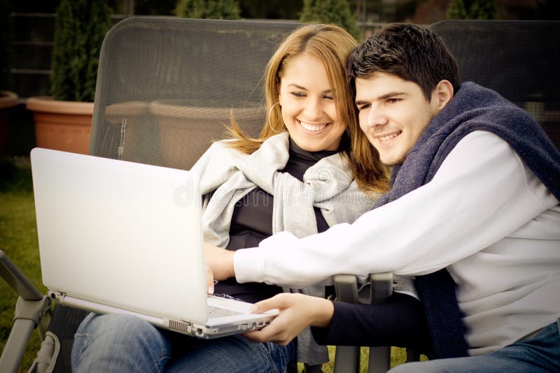 Giovani coppie felici che praticano il surfing il Internet