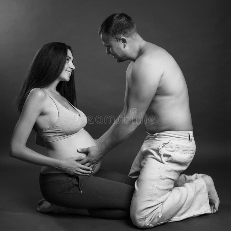 Giovani coppie incinte che abbracciano e che sorridono Amore e tenerezza Aspettando un miracolo Ritratto in bianco e nero T fotografia stock Giovani coppie incinte che abbracciano e che sorridono Amore e tenerezza Aspettando un miracolo Ritratto in bianco e nero T fotografia stock