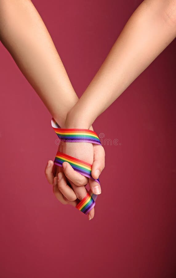 Giovani coppie lesbiche con il nastro dell'arcobaleno fotografie stock libere da diritti Giovani coppie lesbiche con il nastro dell'arcobaleno fotografie stock libere da diritti