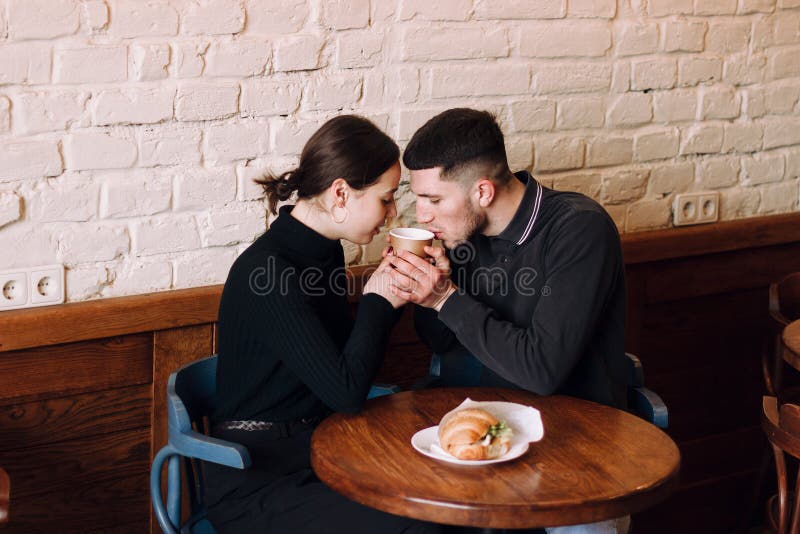 Giovani coppie nell'amore che si siede in un caffè, coffe bevente di mattina fotografie stock libere da diritti Giovani coppie nell'amore che si siede in un caffè, coffe bevente di mattina fotografie stock libere da diritti