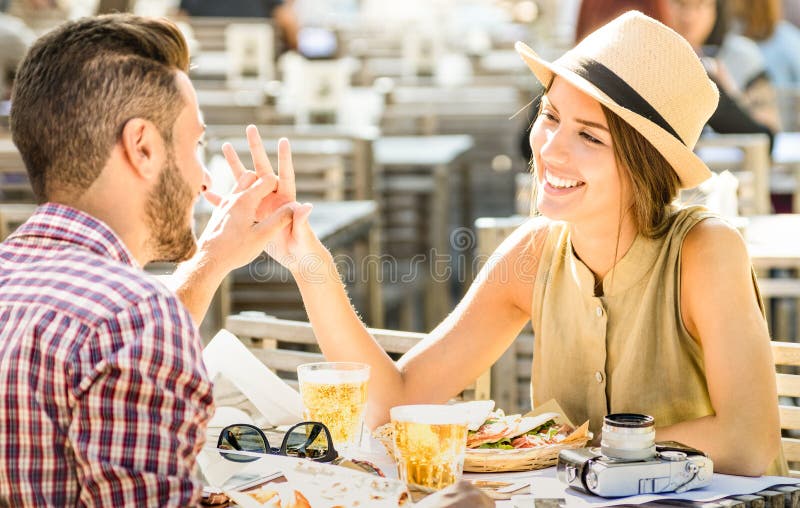 Giovani coppie nell'amore divertendosi alla barra della birra sull'escursione di viaggio fotografia stock libera da diritti Giovani coppie nell'amore divertendosi alla barra della birra sull'escursione di viaggio fotografia stock libera da diritti