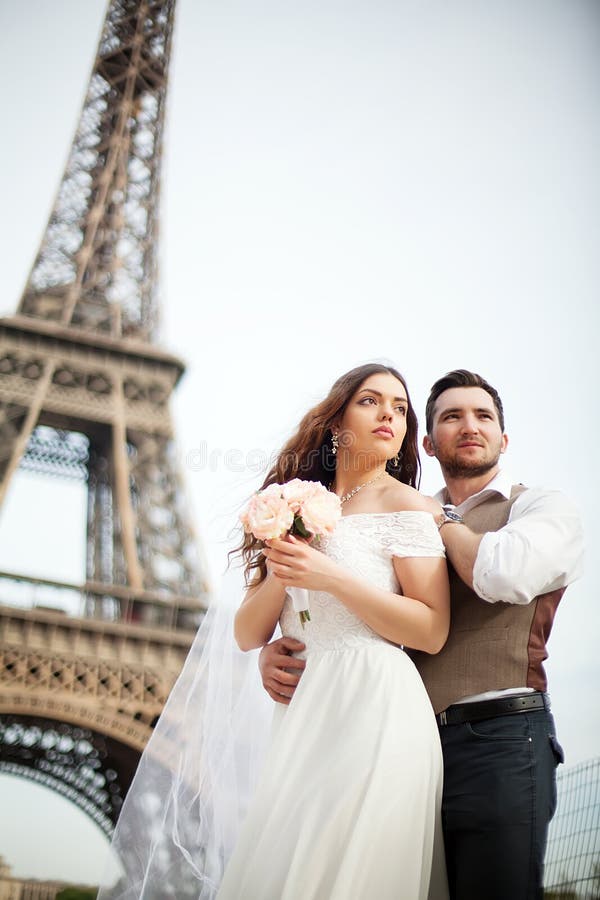 Giovani coppie nell'amore a Parigi sul loro giorno delle nozze immagini stock Giovani coppie nell'amore a Parigi sul loro giorno delle nozze immagini stock