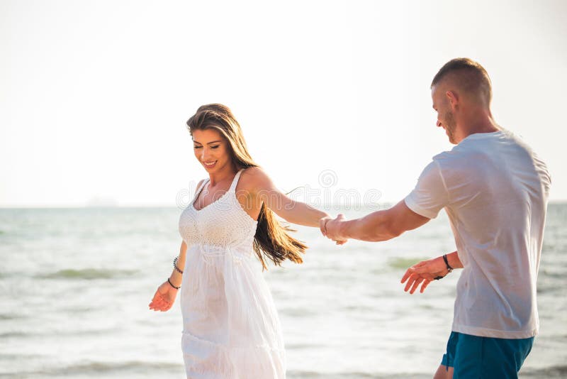 Giovani coppie romantiche adulte caucasiche felici ed allegre che ballano sulla spiaggia tropicale di estate - viaggio di luna di fotografie stock libere da diritti Giovani coppie romantiche adulte caucasiche felici ed allegre che ballano sulla spiaggia tropicale di estate - viaggio di luna di fotografie stock libere da diritti