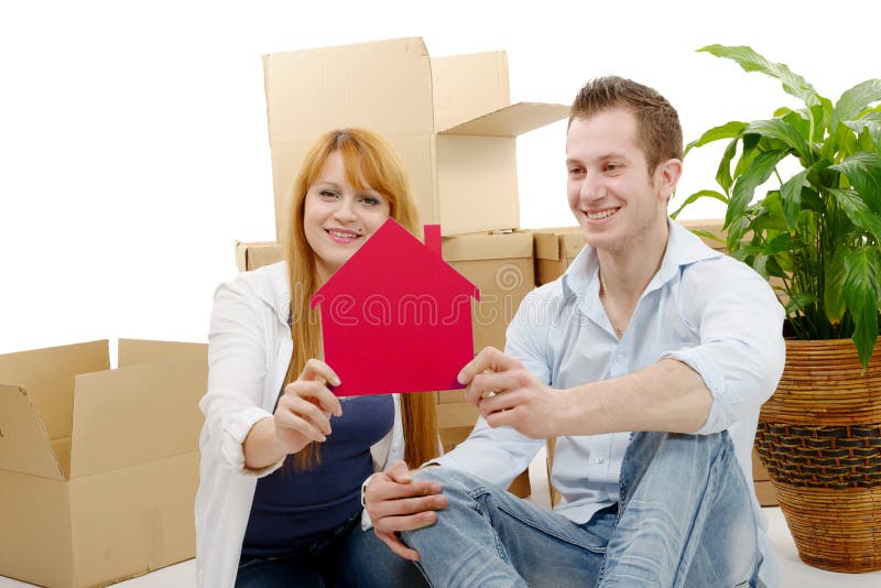 Giovani coppie sorridenti che si siedono dopo la casa commovente fotografia stock libera da diritti Giovani coppie sorridenti che si siedono dopo la casa commovente fotografia stock libera da diritti