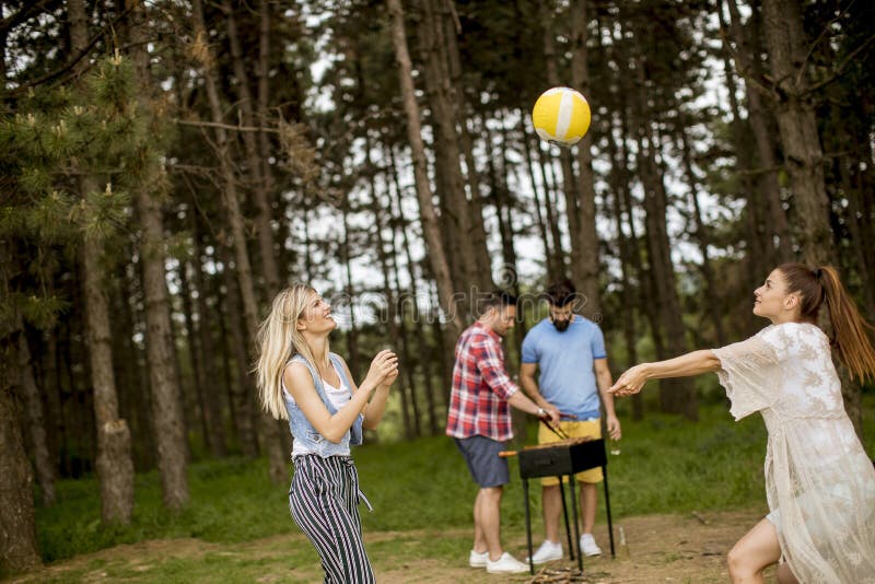Giovani donne che giocano pallavolo su picnik nella natura di primavera immagini stock Giovani donne che giocano pallavolo su picnik nella natura di primavera immagini stock