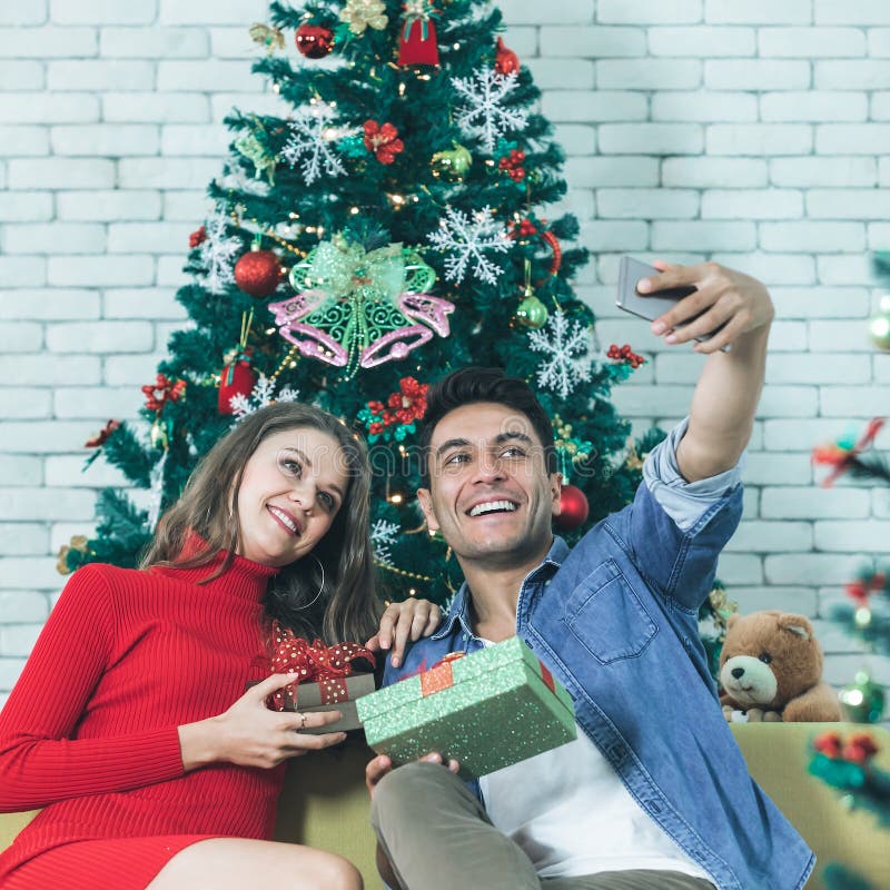 Giovani e belle coppie caucasiche che si siedono sull'felice del sofà fotografie stock Giovani e belle coppie caucasiche che si siedono sull'felice del sofà fotografie stock
