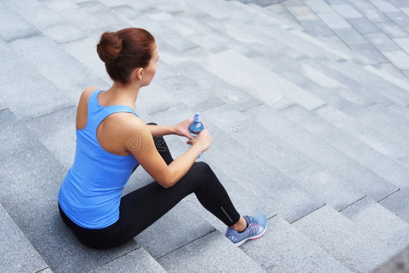 Giovani, misura e donna sportiva riposanti dopo l'addestramento Forma fisica, sport, pareggiare urbano, concetto sano di stile di immagine stock Giovani, misura e donna sportiva riposanti dopo l'addestramento Forma fisica, sport, pareggiare urbano, concetto sano di stile di immagine stock