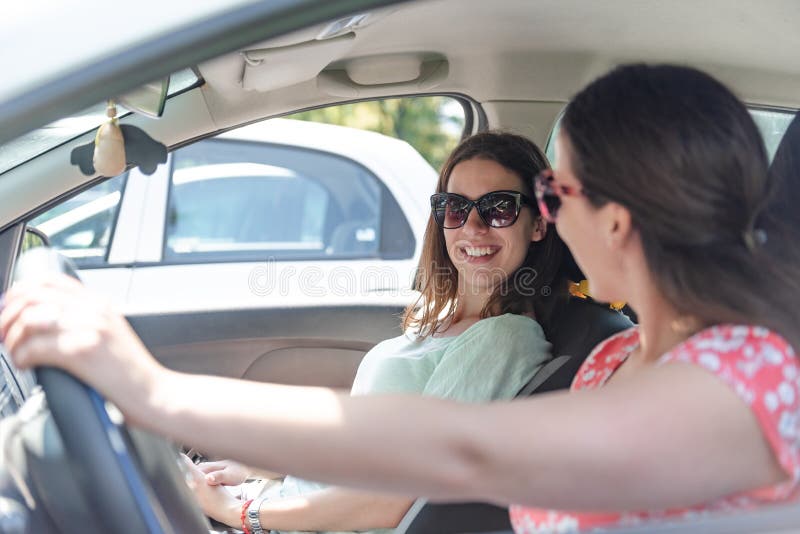 Giovani ragazze migliori amiche che si divertono durante un viaggio in macchina, il concetto di trasporto e la vita ordinaria in c fotografia stock libera da diritti Giovani ragazze migliori amiche che si divertono durante un viaggio in macchina, il concetto di trasporto e la vita ordinaria in c fotografia stock libera da diritti