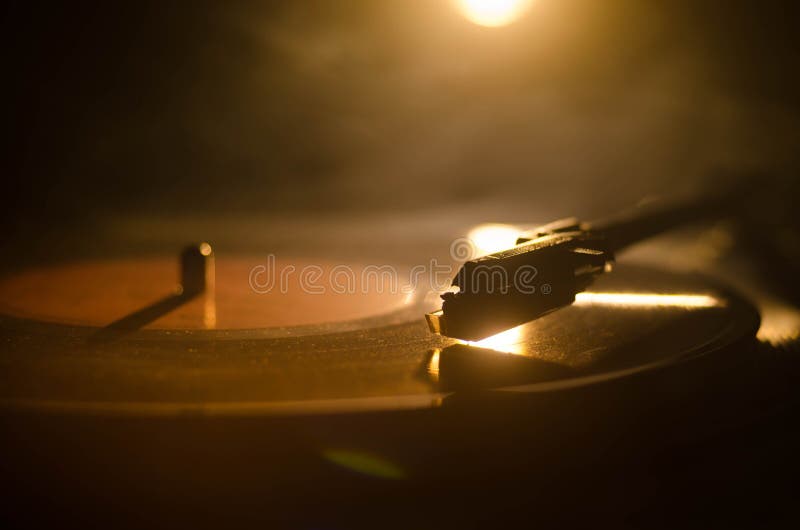 Turntable vinyl record player. Retro audio equipment for disc jockey. Sound technology for DJ to mix & play music. Vinyl record being played against burning fire background with smoke. Turntable vinyl record player. Retro audio equipment for disc jockey. Sound technology for DJ to mix & play music. Vinyl record being played against burning fire background with smoke