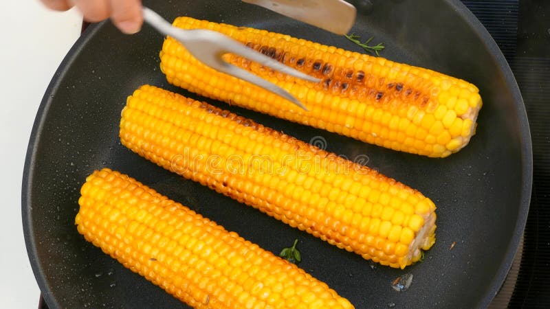 Gire as espigas de milho cozinhadas em uma frigideira