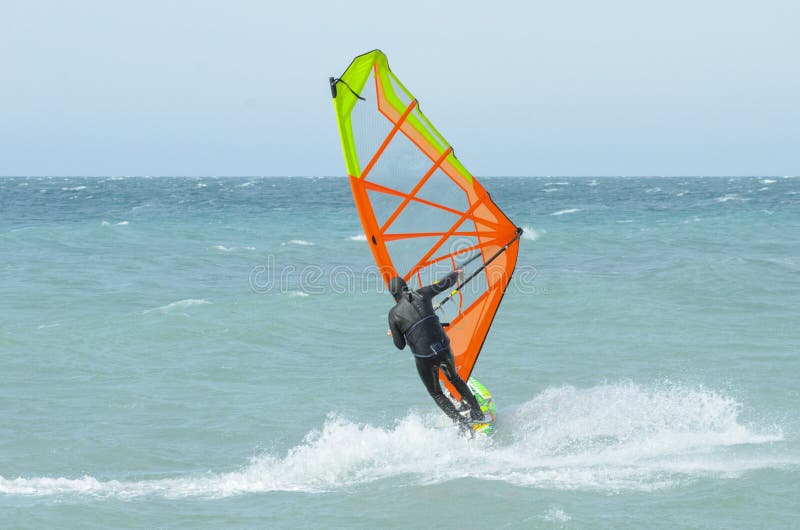 Extreme sportsman windsurfer rides on a Board sail on the Black sea near the coast of Anapa, Krasnodar region, Russia. Extreme sportsman windsurfer rides on a Board sail on the Black sea near the coast of Anapa, Krasnodar region, Russia