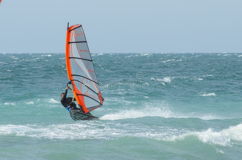 Extreme sportsman windsurfer rides on a Board sail on the Black sea near the coast of Anapa, Krasnodar region, Russia. Extreme sportsman windsurfer rides on a Board sail on the Black sea near the coast of Anapa, Krasnodar region, Russia