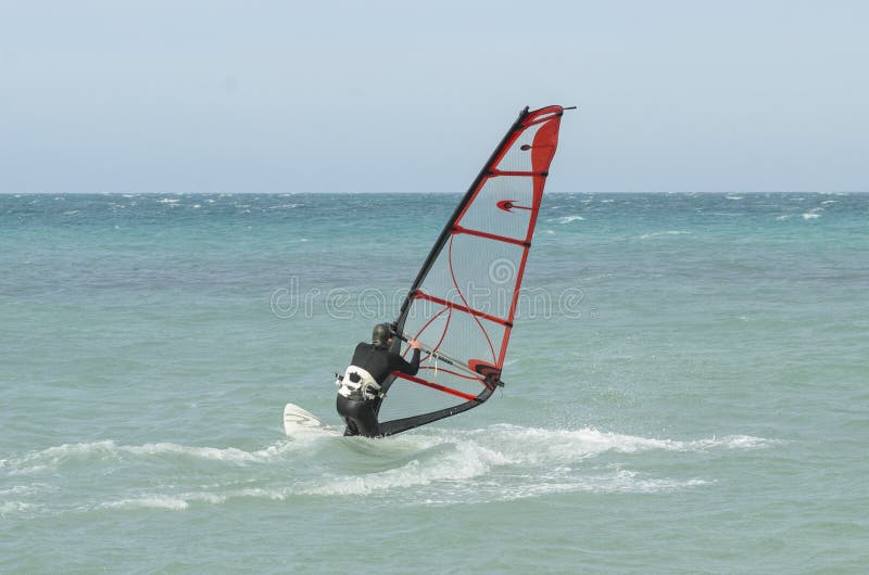 Extreme sportsman windsurfer rides on a Board sail on the Black sea near the coast of Anapa, Krasnodar region, Russia. Extreme sportsman windsurfer rides on a Board sail on the Black sea near the coast of Anapa, Krasnodar region, Russia