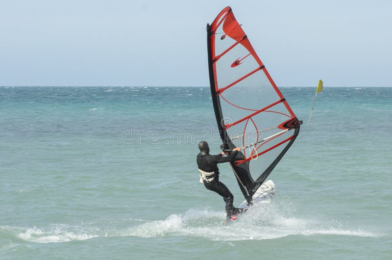 Extreme sportsman windsurfer rides on a Board sail on the Black sea near the coast of Anapa, Krasnodar region, Russia. Extreme sportsman windsurfer rides on a Board sail on the Black sea near the coast of Anapa, Krasnodar region, Russia