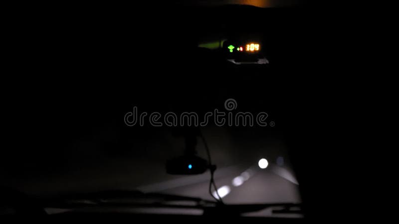Giri dell'automobile sulla strada di notte Vista interna Cruscotto, radio, DVR