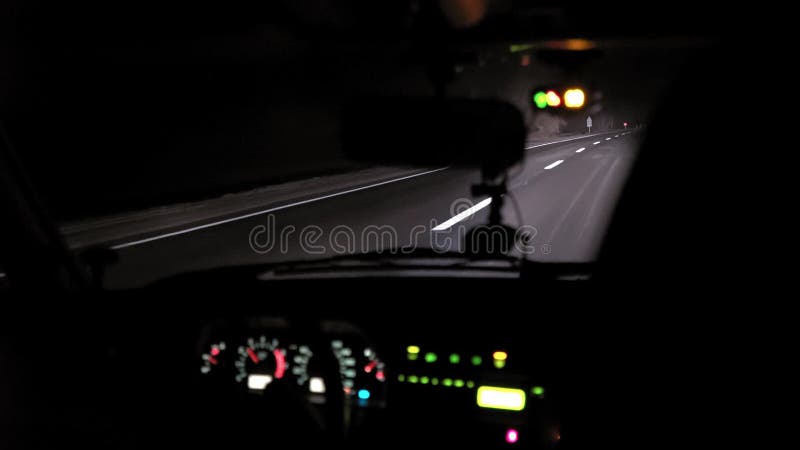 Giri dell'automobile sulla strada di notte Vista interna Cruscotto, radio, DVR