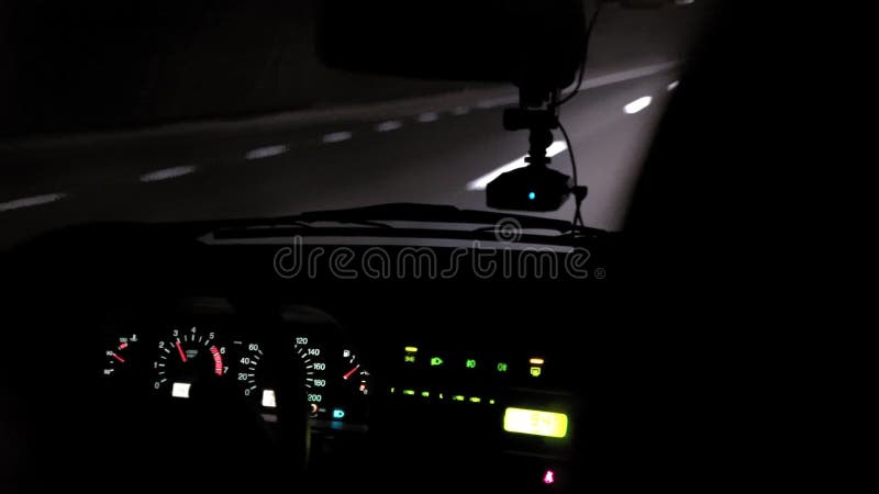 Giri dell'automobile sulla strada di notte Vista interna Cruscotto, radio, DVR