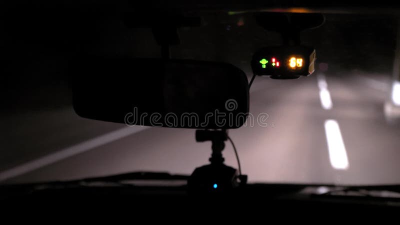 Giri dell'automobile sulla strada di notte Vista interna Cruscotto, radio, DVR