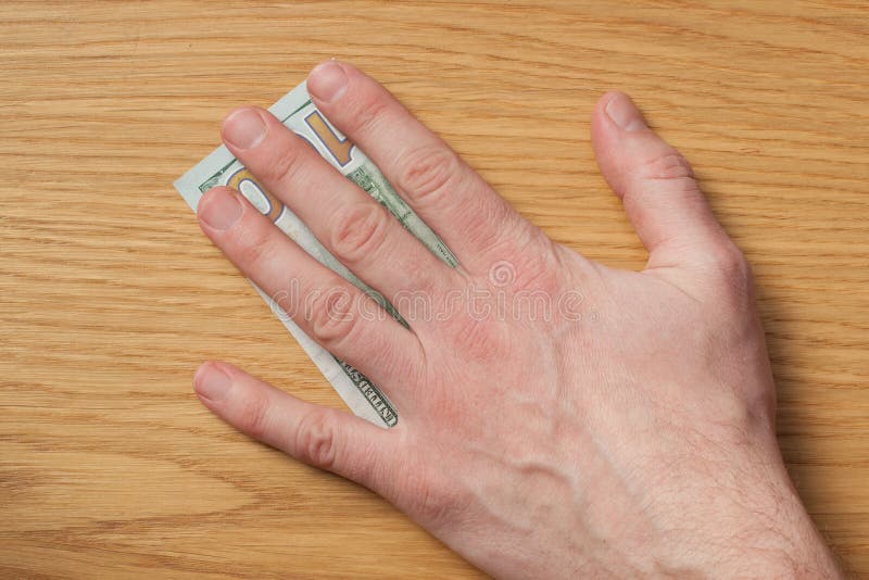Giriga mannens hand tar en muta av hundra oss dollarsedeln över en trätabell royaltyfri foto Giriga mannens hand tar en muta av hundra oss dollarsedeln över en trätabell royaltyfri foto