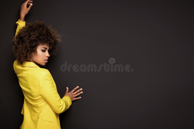Girl with afro hairstyle posing in yellow jacket. stock image Girl with afro hairstyle posing in yellow jacket. stock image