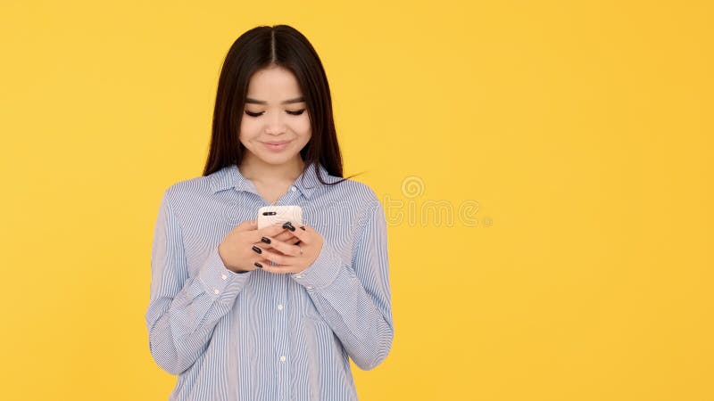 Girl Asian Girl on Yellow Background Texting on a Cell Phone Stock ...