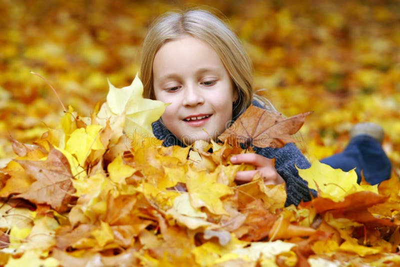 Kids buried in fall leaves stock photo. Image of youth - 7583364