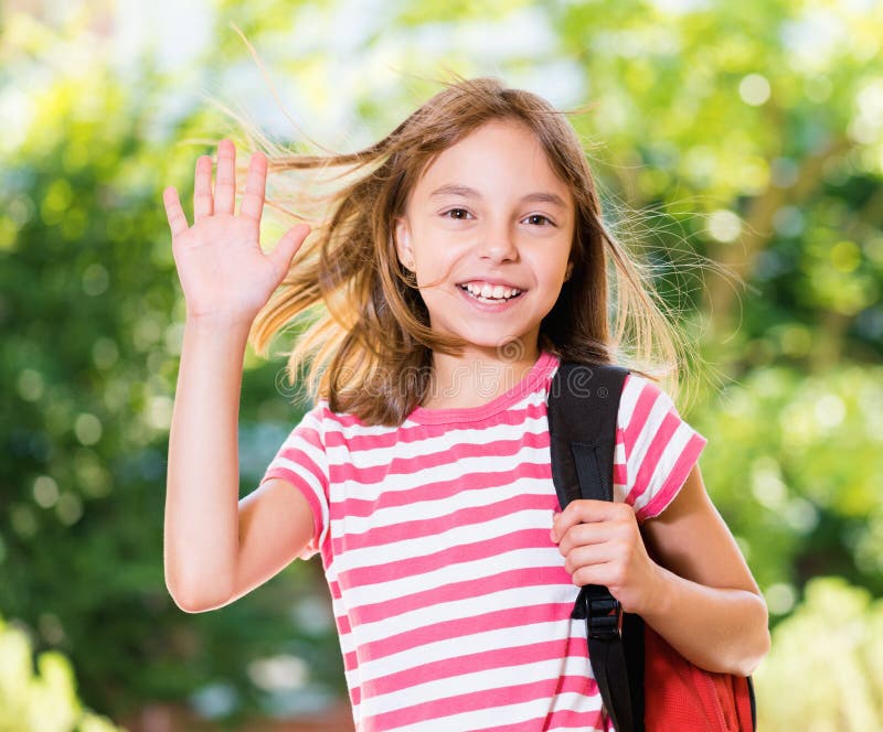 Girl with backpack posing outdoors