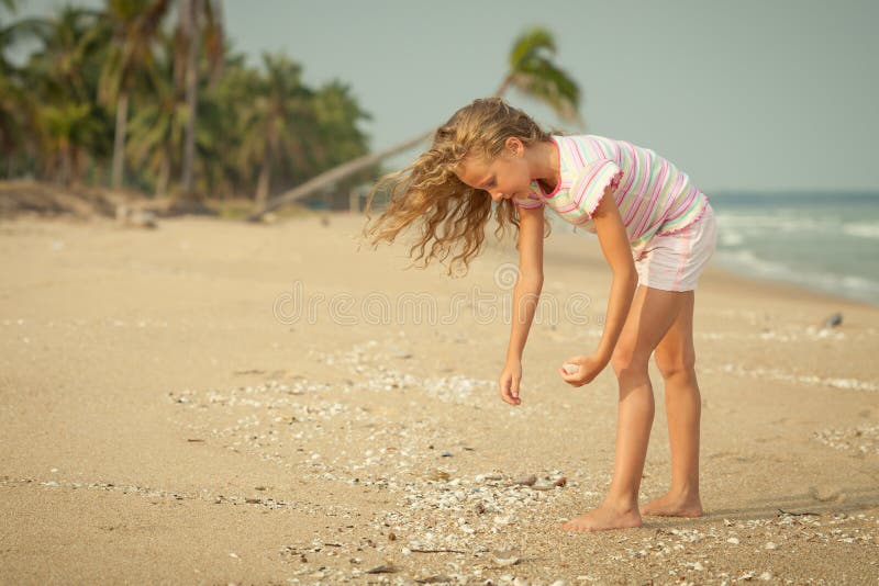 Girl on the beach collecting shells