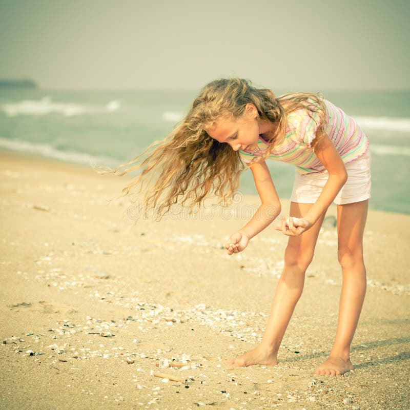 Girl on the beach collecting shells