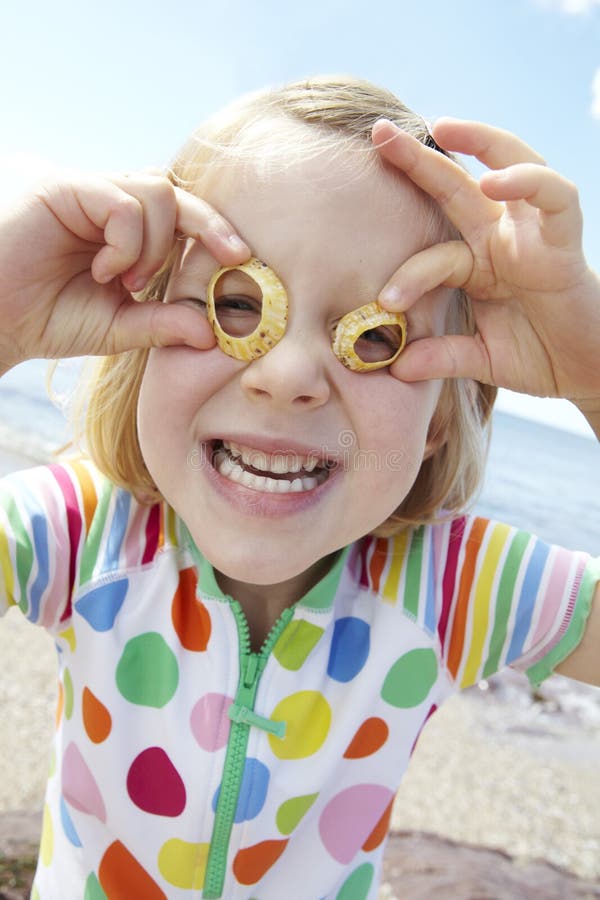 Girl On Beach Making Glasses From Seashells