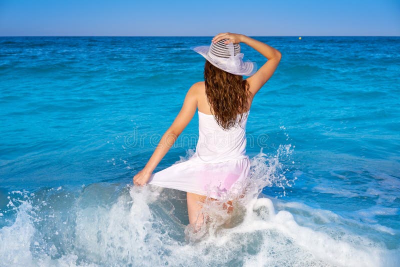 Girl in beach sea shore with waves splash